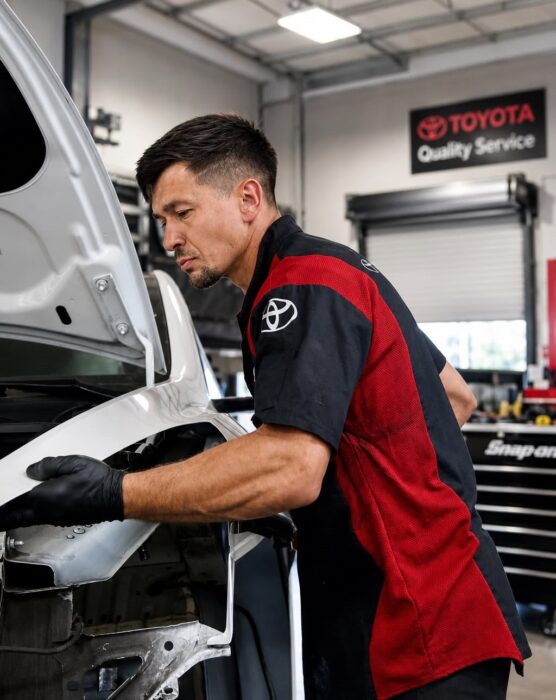 Collision repair technician working on a vehicle